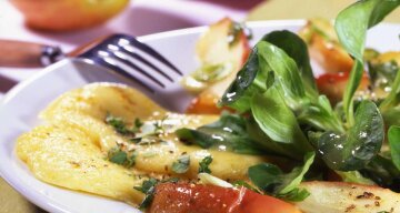 Gratinierte Bergkäse-Scheiben mit karamellisierten Apfelspalten, dazu Feldsalat
