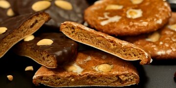 Halbierte schwarze und braune Elisenlebkuchen mit Mandeln.