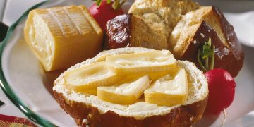 eine Laugensemmel belegt mit Butter und 4 Romadurscheiben