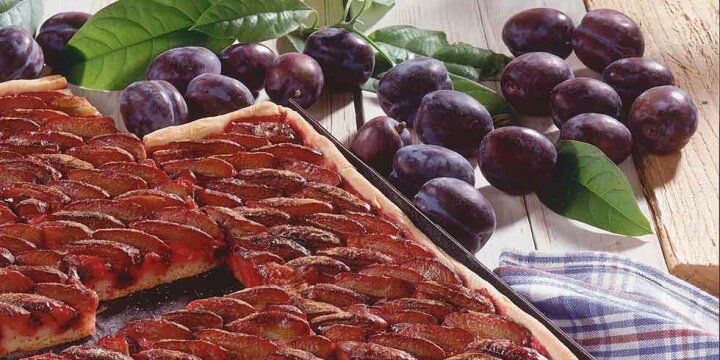 Zwetschgen neben Blechkuchen