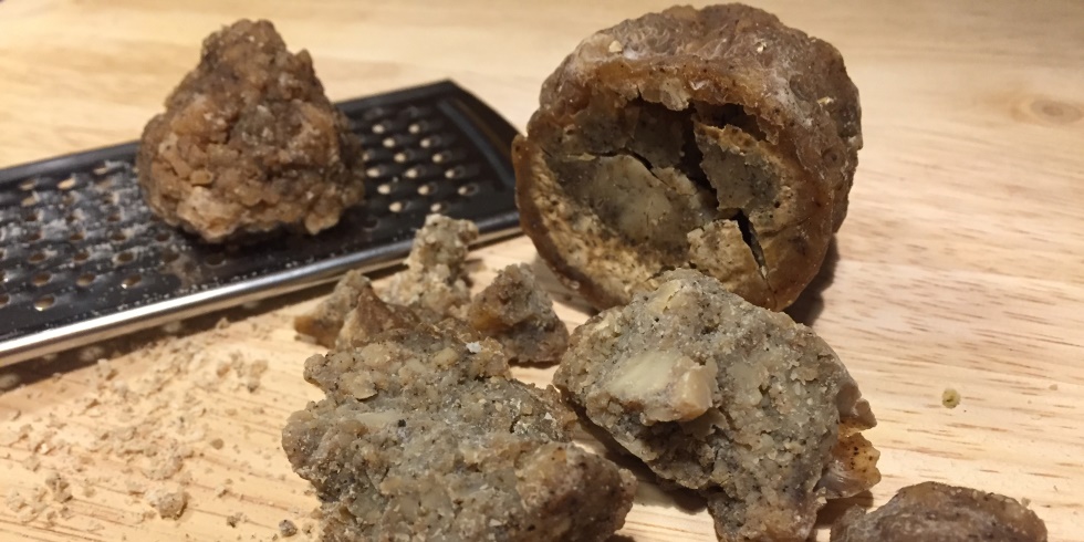 eine auseinandergebrochene Kugel Beieikas, daneben eine Reibe mit einem Stück davon