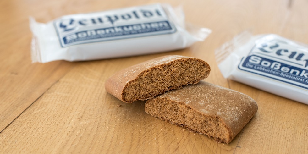 hältig gebrochener Soßenkuchen, im Hintergrund zwei verpackte Produkte